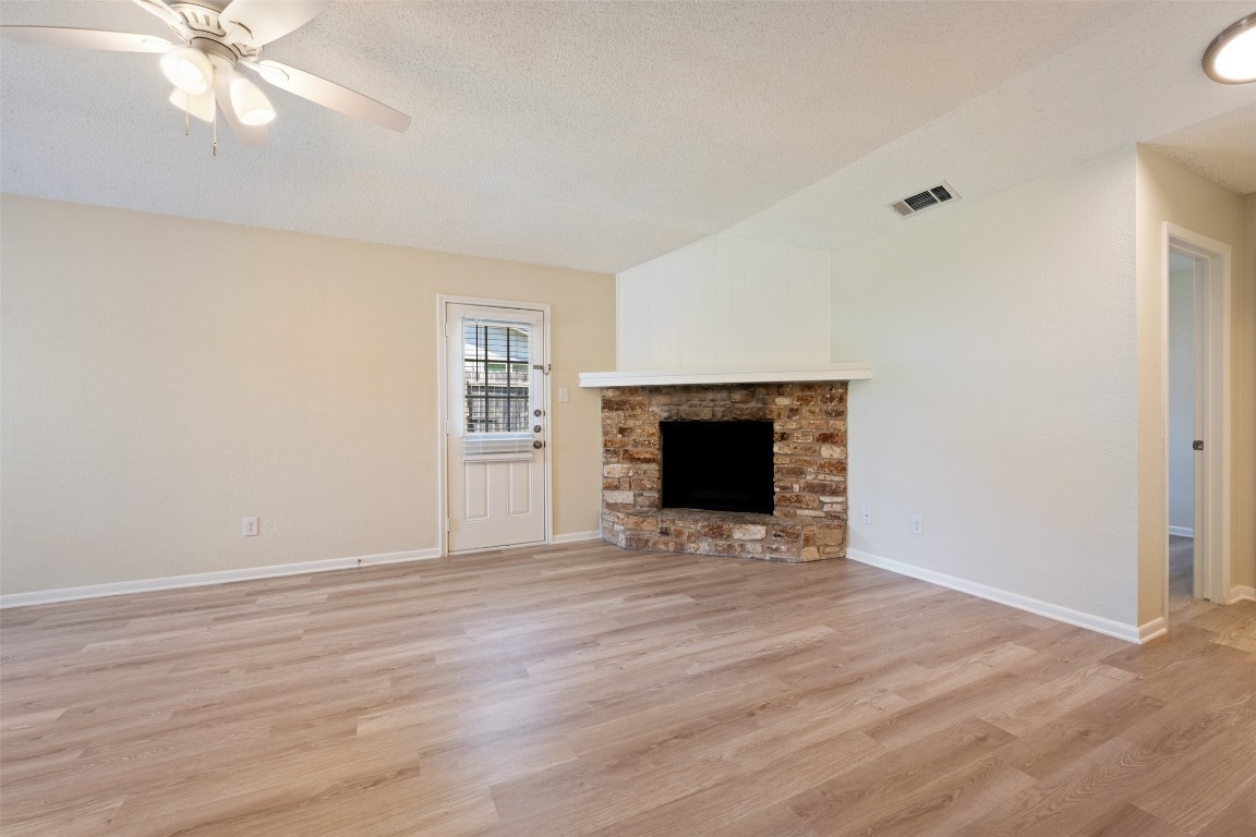 608 Country Aire Drive, Unit A Round Rock, TX 78664 - Photo 10 of 32 a view of empty room with wooden floor and fireplace