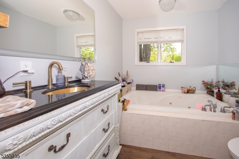76 Glen Road Wantage, NJ 07461 - Photo 24 of 47 a bathroom with a tub a sink and a window