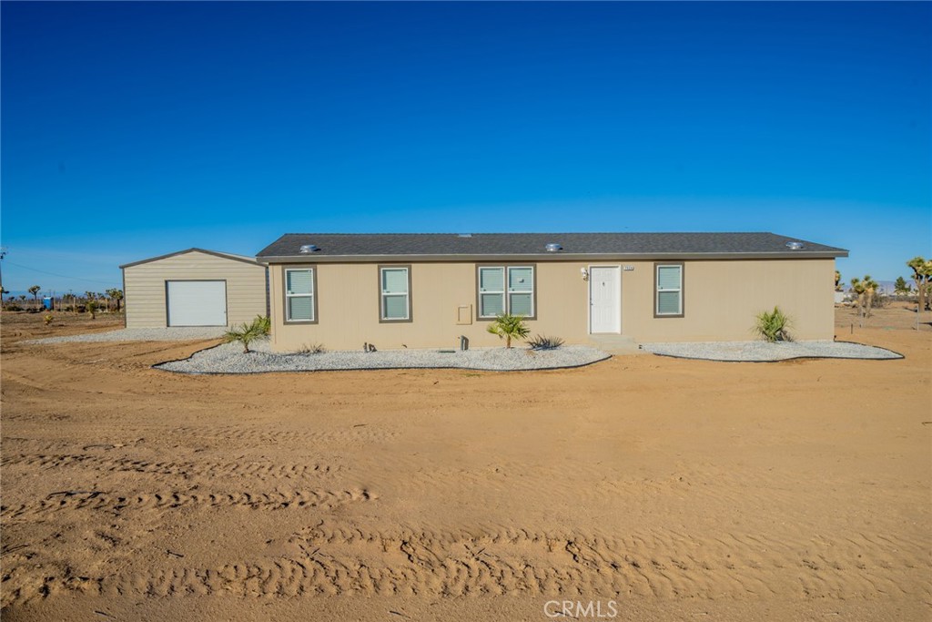7524 Solano Road Phelan, CA 92371 - Photo 1 of 1 a front view of a house with a garden and yard