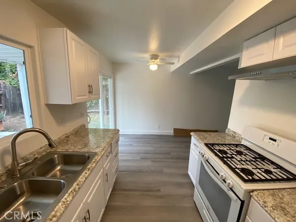 a kitchen with granite countertop a stove and a sink