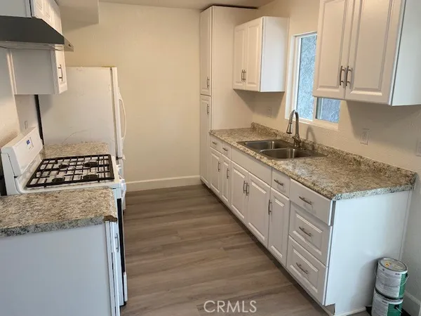 a kitchen with granite countertop a sink stove and cabinets