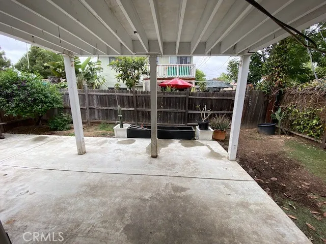 a view of a garage with a table and chairs under an umbrella