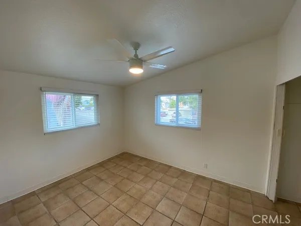 an empty room with a ceiling fan and window