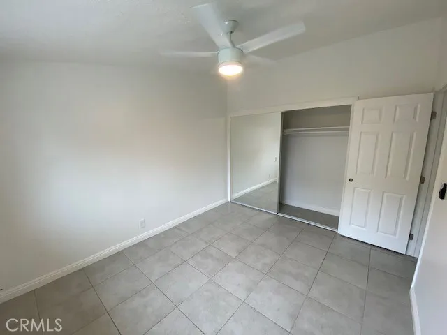 an empty room with a ceiling fan and carpet