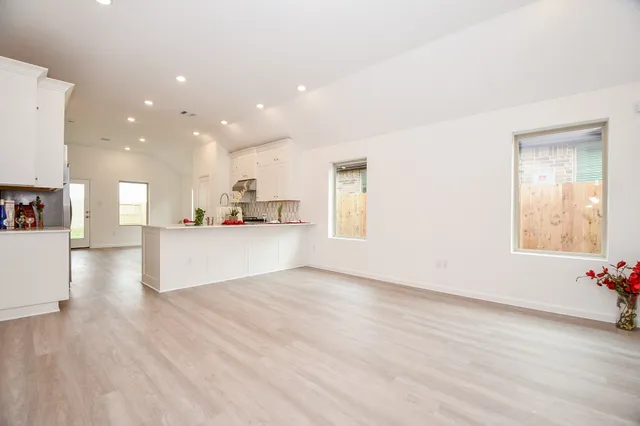 a view of a kitchen with kitchen island wooden floors and stainless steel appliances