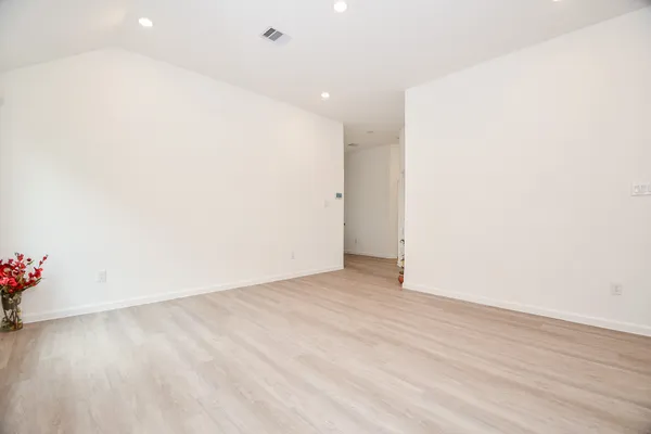 an empty room with wooden floor and flowers