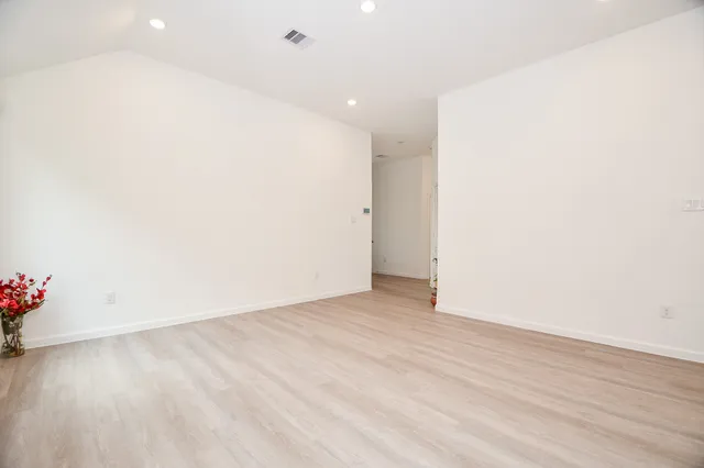 an empty room with wooden floor and flowers