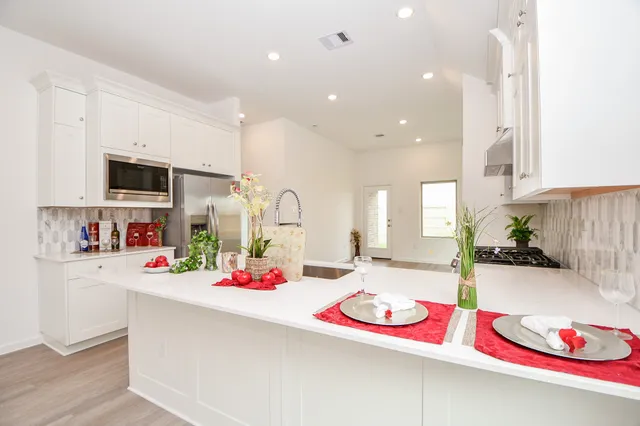 a kitchen with white cabinets and sink