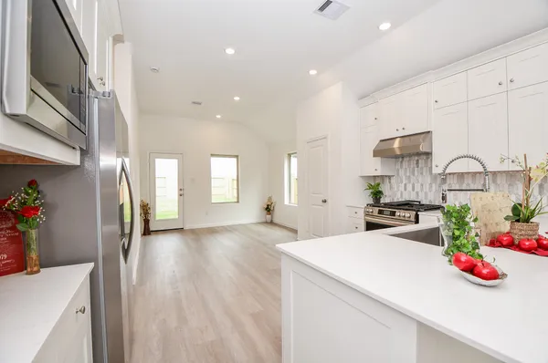 a kitchen with stainless steel appliances granite countertop a sink stove and cabinets