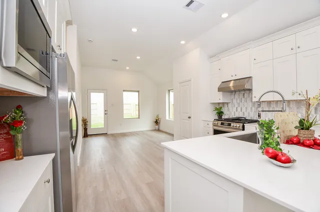 a kitchen with stainless steel appliances granite countertop a sink stove and cabinets