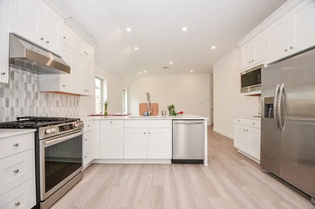 a kitchen with white cabinets and stainless steel appliances