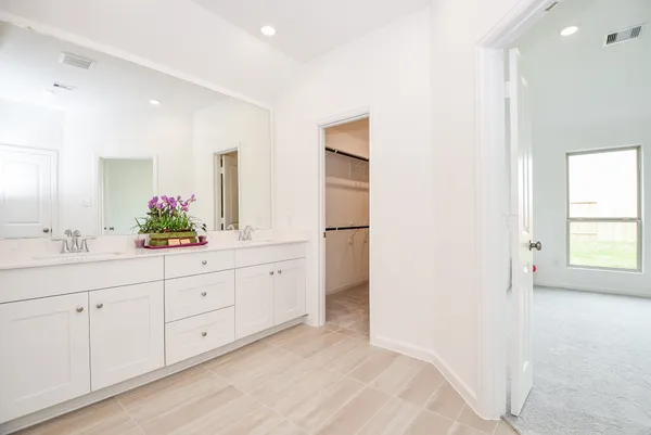 a spacious bathroom with a double vanity sink and a mirror