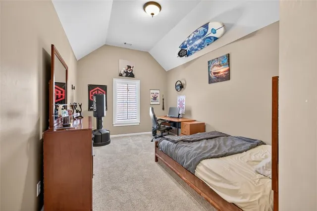 a view of a brick house next to a yard with large trees