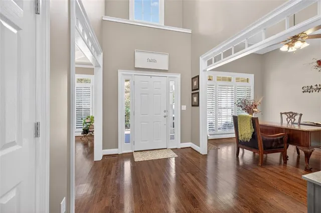 a dining room with furniture a chandelier and wooden floor