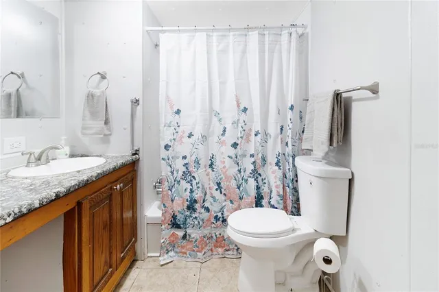 a bathroom with a granite countertop sink a toilet and a mirror