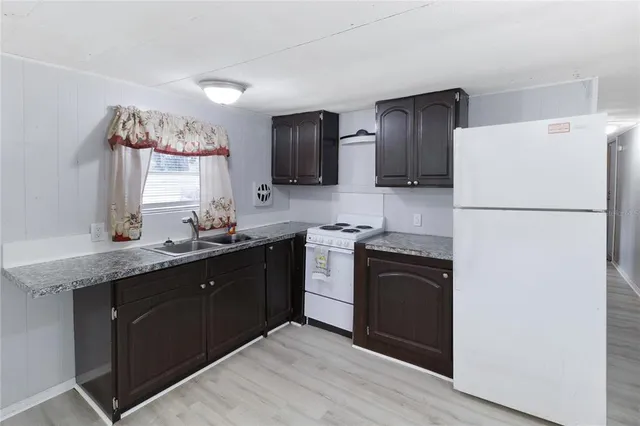 a kitchen with a refrigerator and a sink