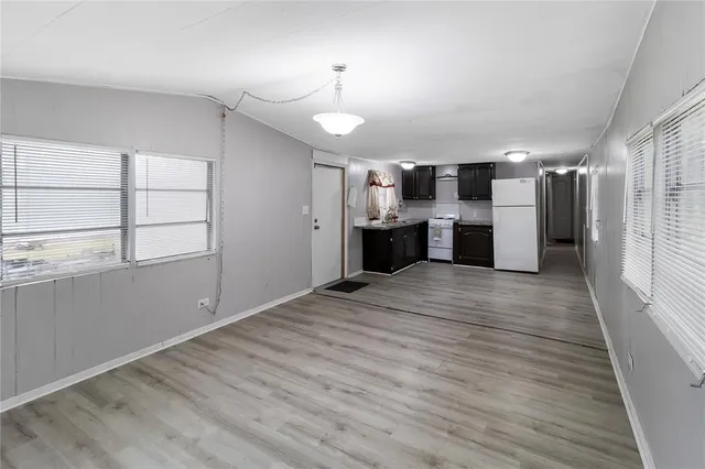 a view of empty room with wooden floor and window