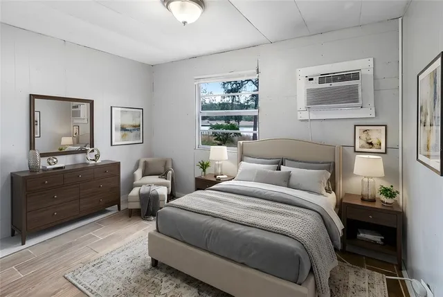 a bedroom with bed cabinet and window