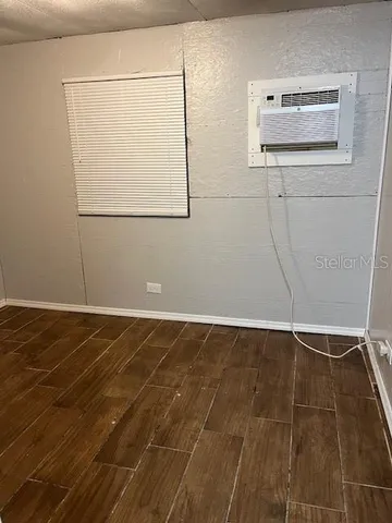 a view of a room with wooden floor and a window