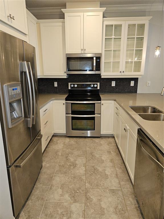 2812 Cello Lane Kissimmee, FL 34741 - Photo 5 of 34 a kitchen with a refrigerator stove and cabinets