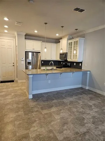 a large kitchen with cabinets and a refrigerator