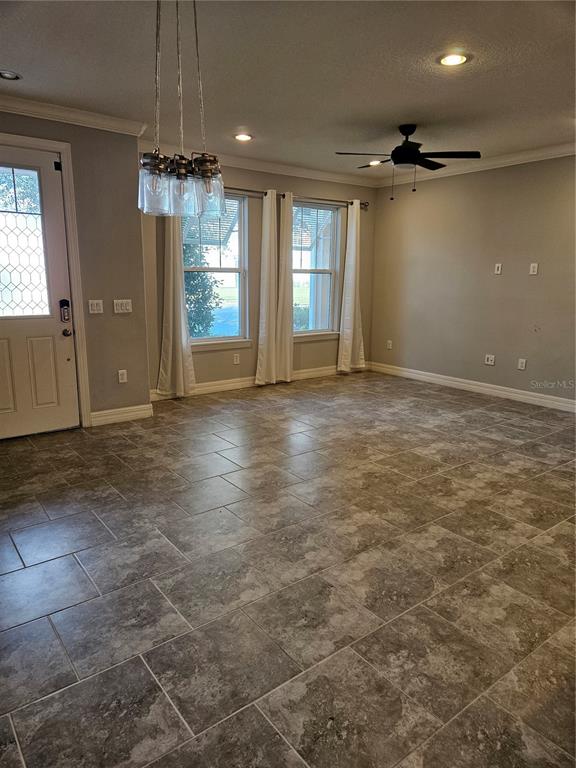 2812 Cello Lane Kissimmee, FL 34741 - Photo 10 of 34 an empty room with chandelier fan and windows
