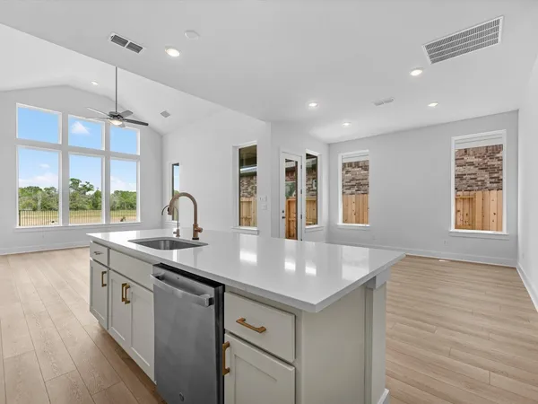 a kitchen with a sink stove and wooden floor
