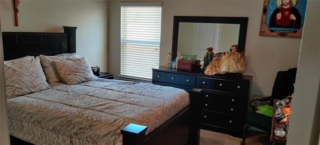 a bedroom with a bed and a dresser with mirror