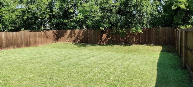 a view of garden with wooden fence