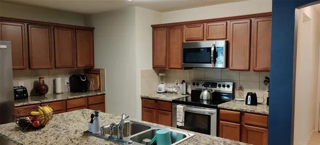 a kitchen with stainless steel appliances granite countertop a stove and cabinets