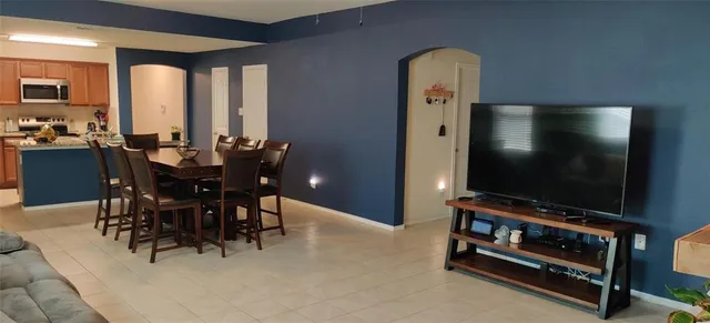 a dining room with furniture and chandelier floor to ceiling window