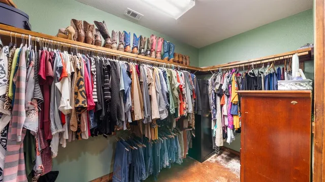 a view of walk in closet with clothes and shoes