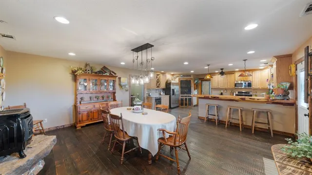 a dining area with a table chairs and a kitchen view