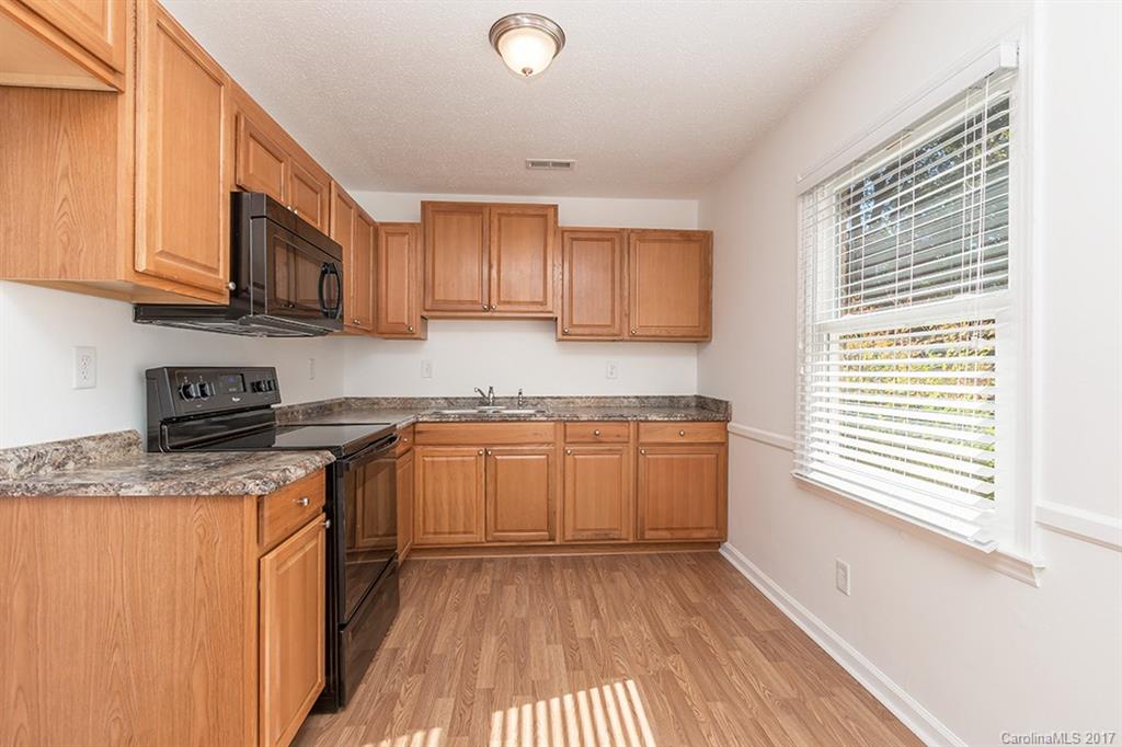 1705 Rushing Street, Unit 38 Monroe, NC 28112 - Photo 5 of 21 a kitchen with stainless steel appliances granite countertop a stove a sink and a microwave