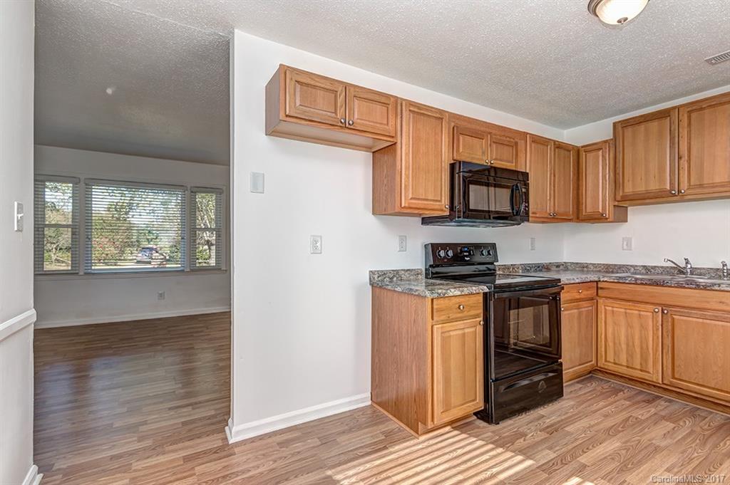1705 Rushing Street, Unit 38 Monroe, NC 28112 - Photo 6 of 21 a kitchen with stainless steel appliances granite countertop a stove a sink and a microwave