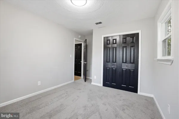 an empty room with closet and windows