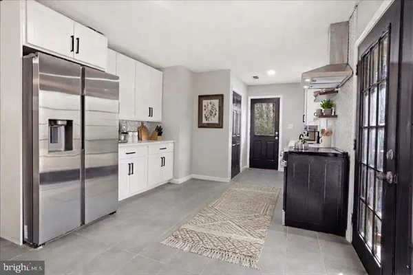 a kitchen with stainless steel appliances granite countertop a refrigerator and a refrigerator