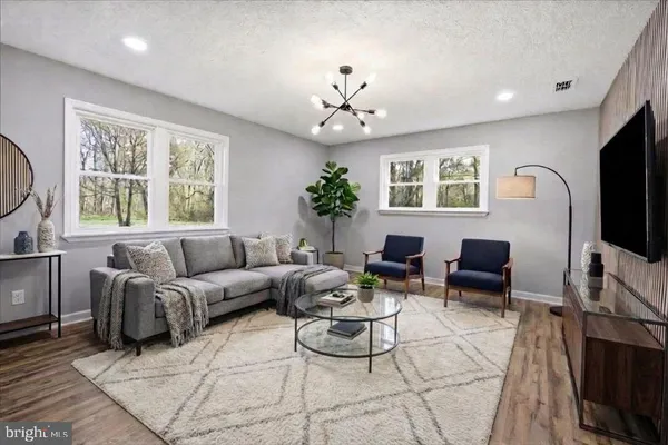 a living room with furniture a large window and a flat screen tv