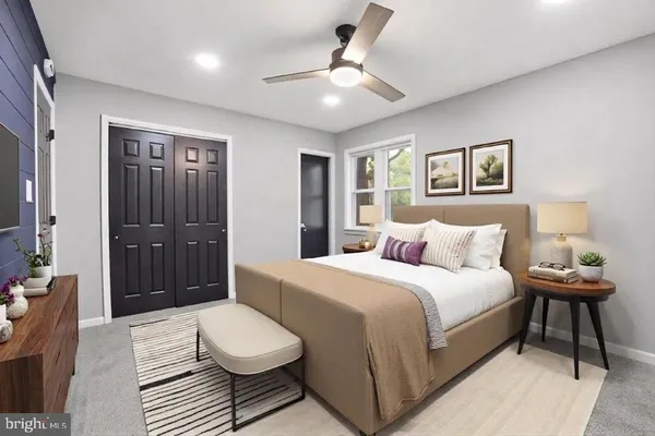 a bedroom with a bed and a lamp on dresser