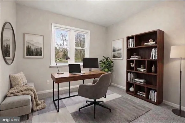 a view of a livingroom with workspace and a couch