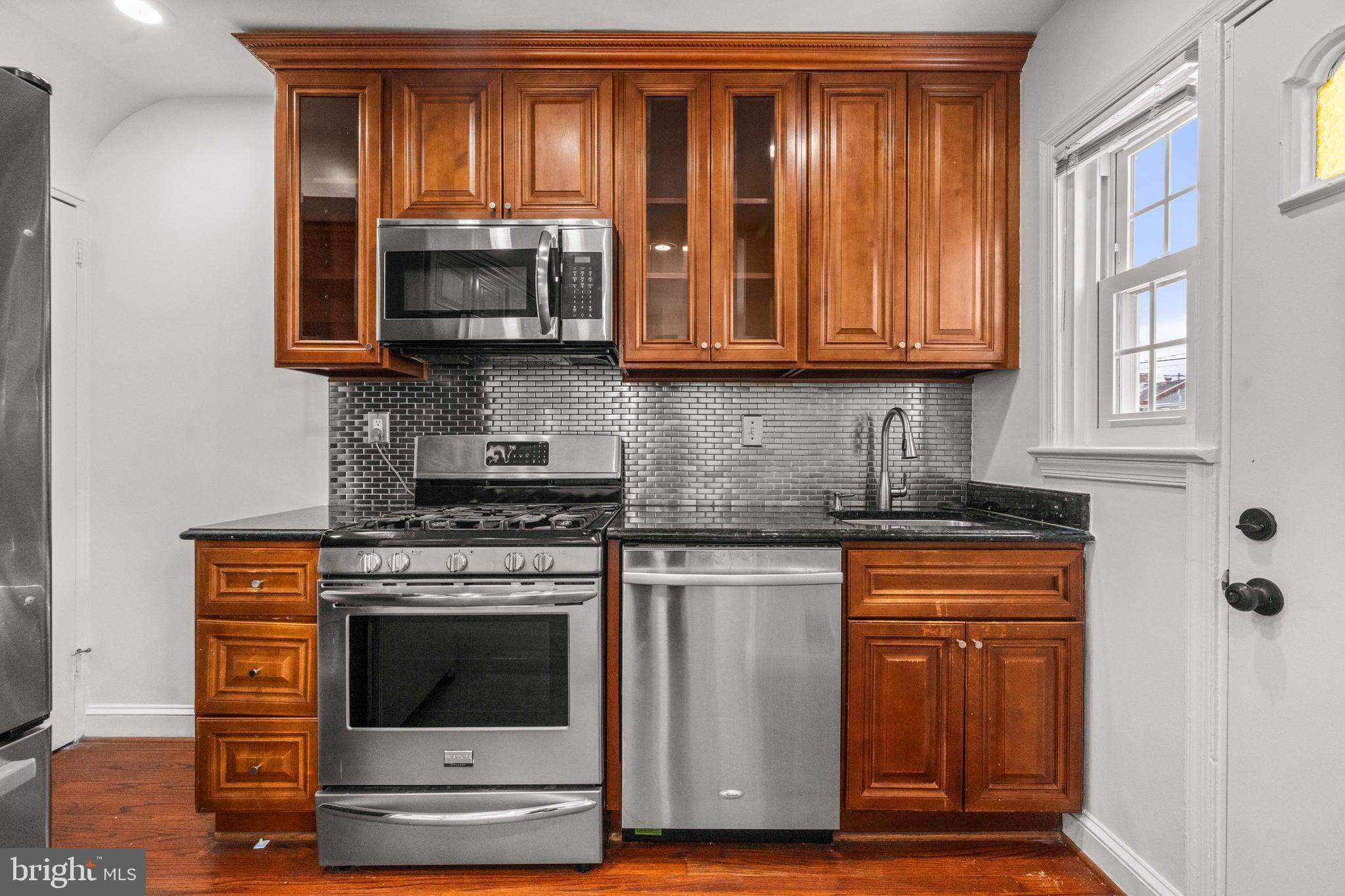 4244 Hildreth Street Southeast Washington, DC 20019 - Photo 7 of 31 a kitchen with granite countertop a stove and a microwave