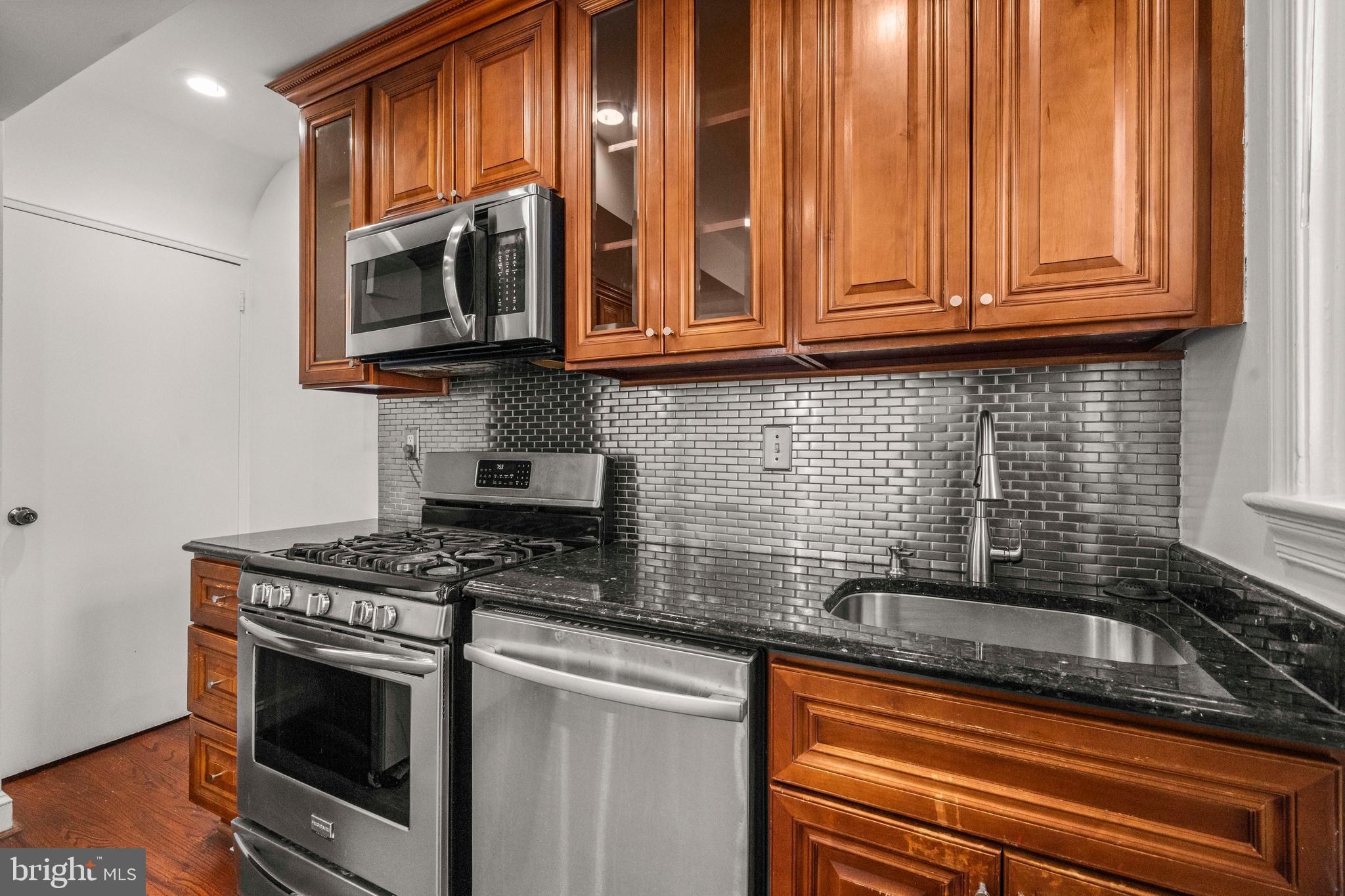 4244 Hildreth Street Southeast Washington, DC 20019 - Photo 8 of 31 a kitchen with stainless steel appliances granite countertop white cabinets and a stove top oven