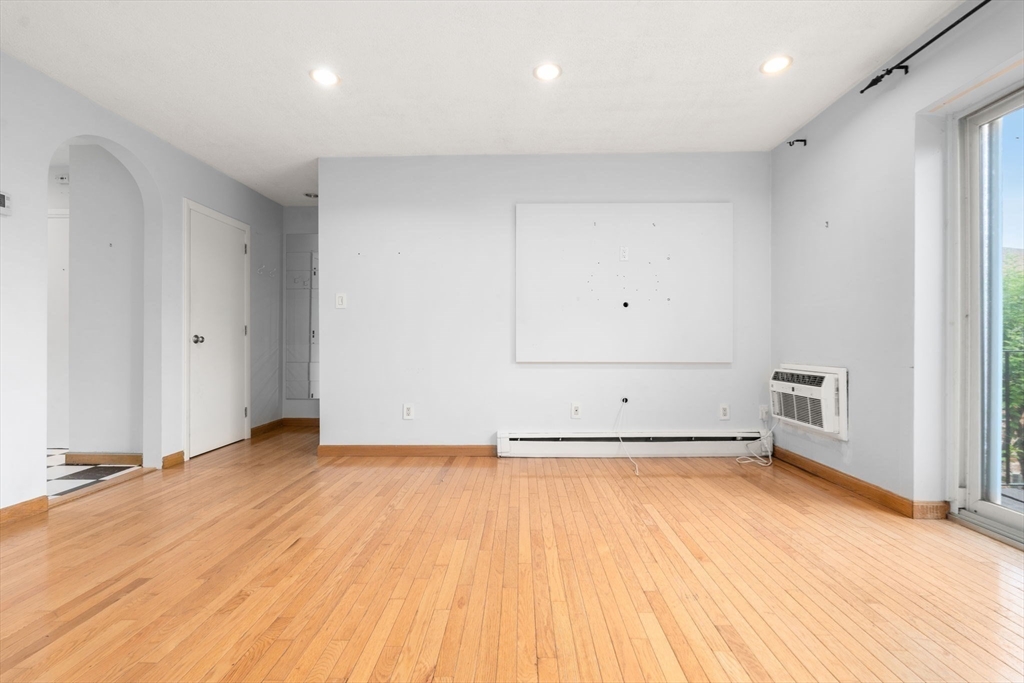 21 Westgate Road, Unit 6 Chestnut Hill, MA 02467 - Photo 13 of 28 an empty room with wooden floor and white walls