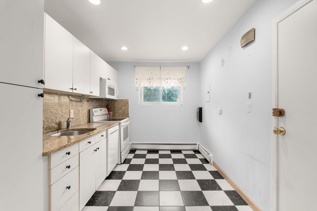 21 Westgate Road, Unit 6 Chestnut Hill, MA 02467 - Photo 4 of 28 a kitchen with a checkered floor and white cabinets