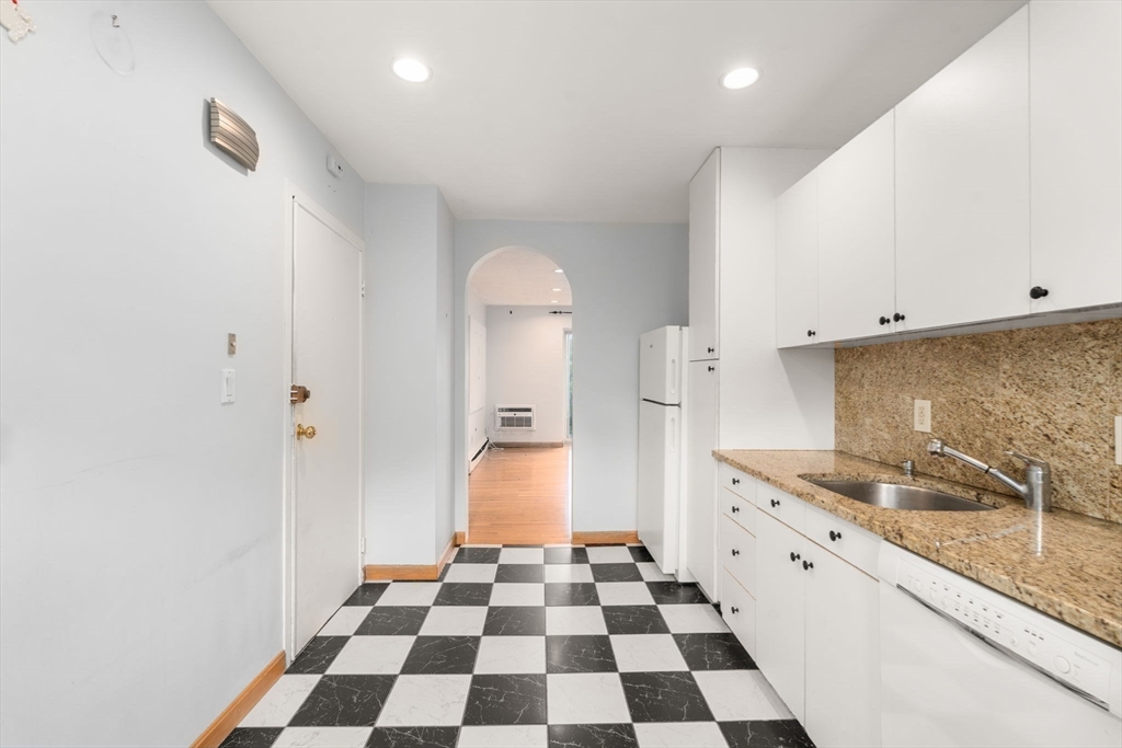 21 Westgate Road, Unit 6 Chestnut Hill, MA 02467 - Photo 8 of 28 a kitchen with granite countertop white cabinets and stainless steel appliances