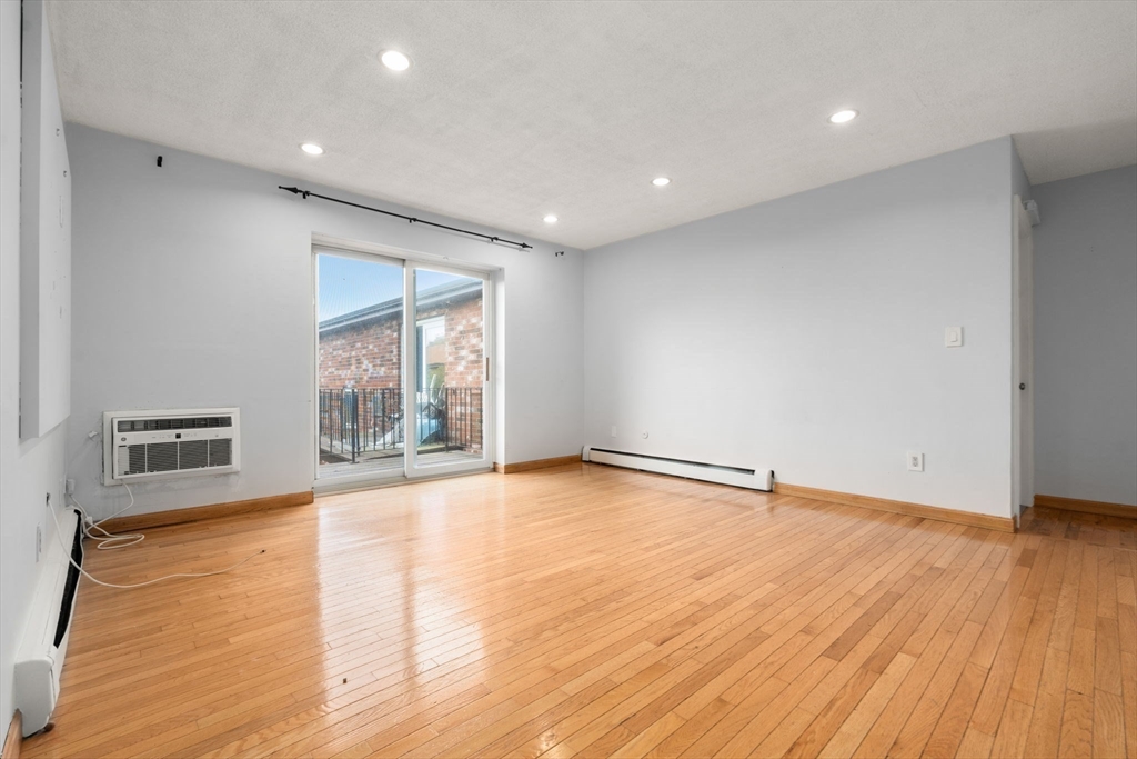 21 Westgate Road, Unit 6 Chestnut Hill, MA 02467 - Photo 9 of 28 a view of an empty room with wooden floor and a window