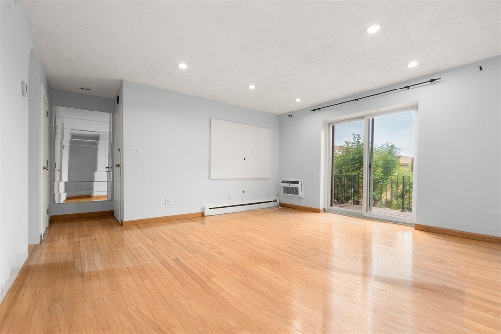 21 Westgate Road, Unit 6 Chestnut Hill, MA 02467 - Photo 10 of 28 a view of an empty room with wooden floor and a window
