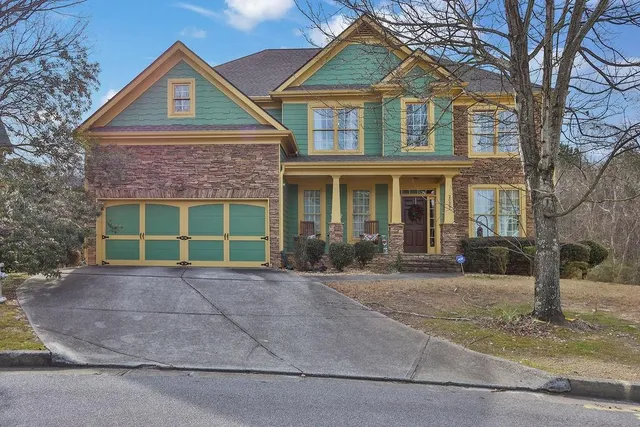 a front view of a house with garden and plants