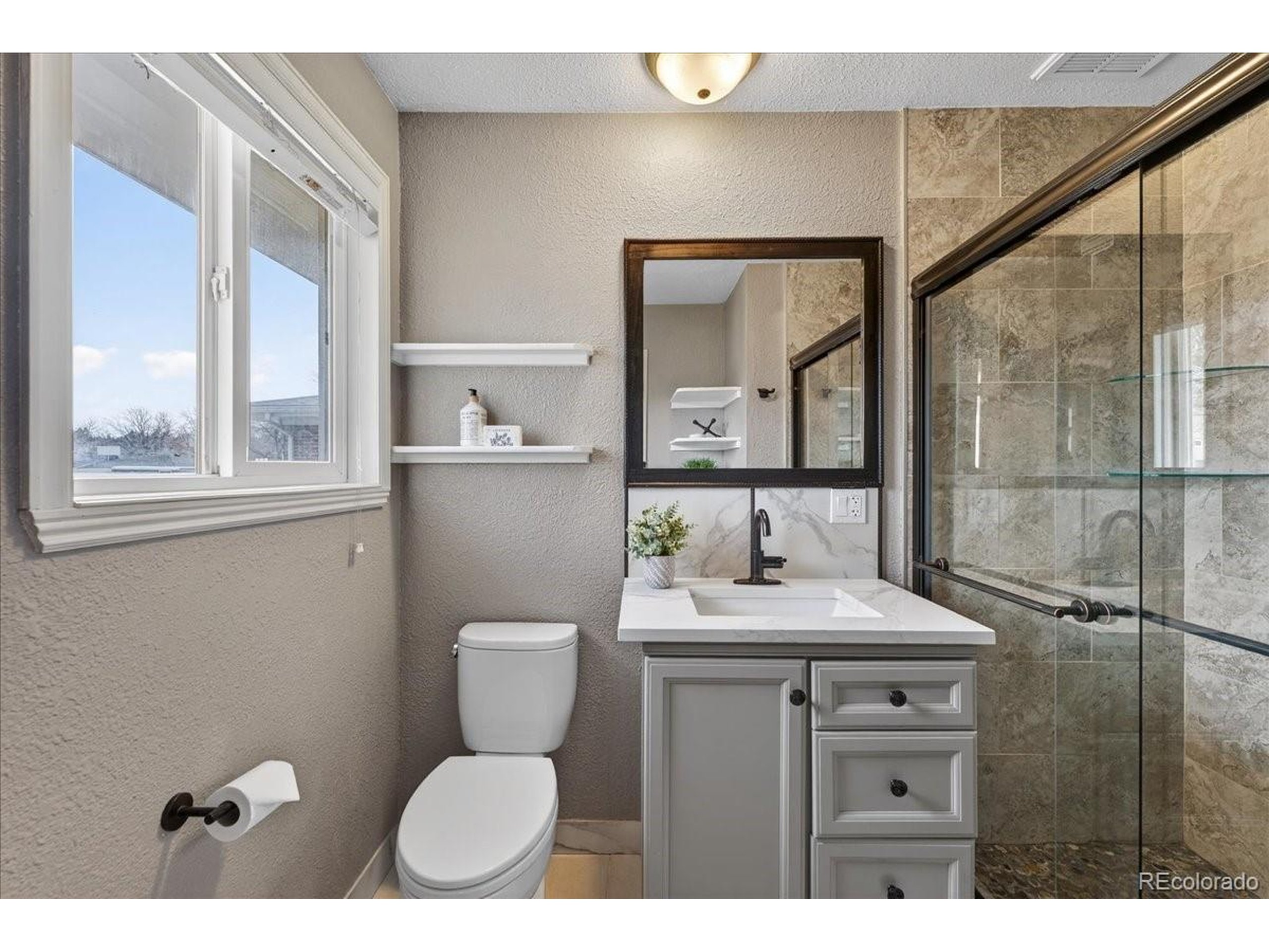 3135 Wright Court Wheat Ridge, CO 80215 - Photo 26 of 50 a bathroom with a toilet a sink and a mirror