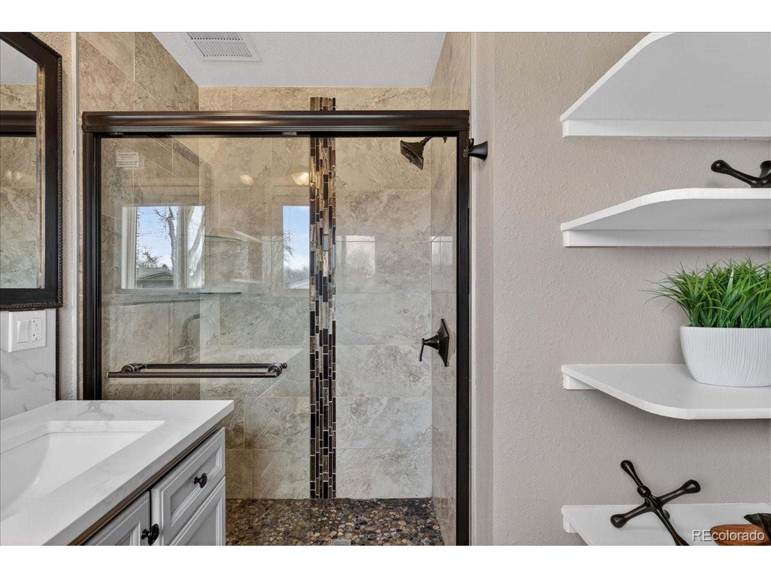 3135 Wright Court Wheat Ridge, CO 80215 - Photo 27 of 50 a bathroom with a granite countertop sink mirror and a shower